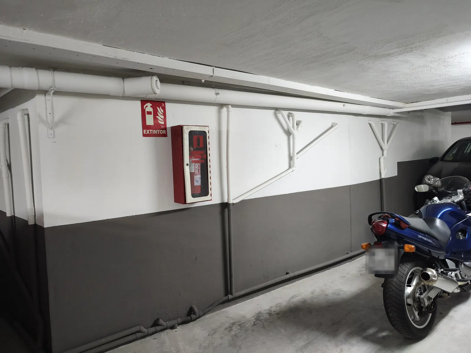 Muro del garaje seco y pintado, con el colector del sistema en la base, en junio de 2026