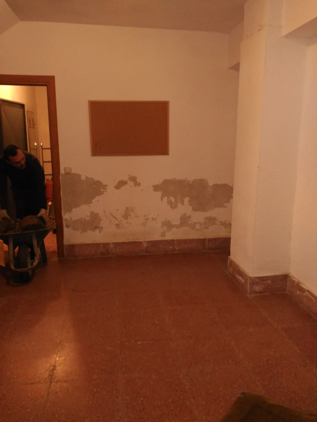 Portal de la urbanización con la humedad marcada en la parte baja de los muros