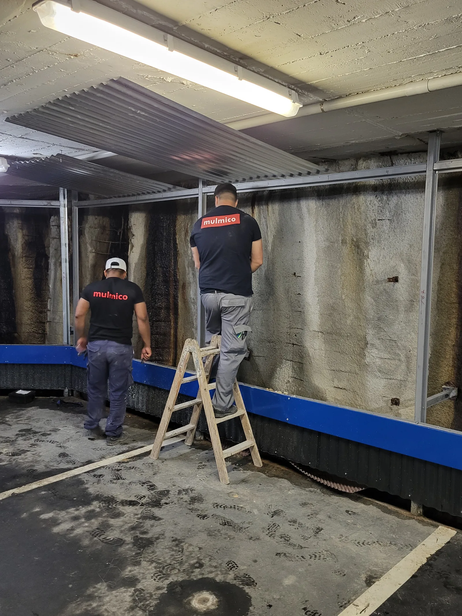 Estructura metálica y chapa grecada instaladas para ocultar un muro de sótano afectado por humedad